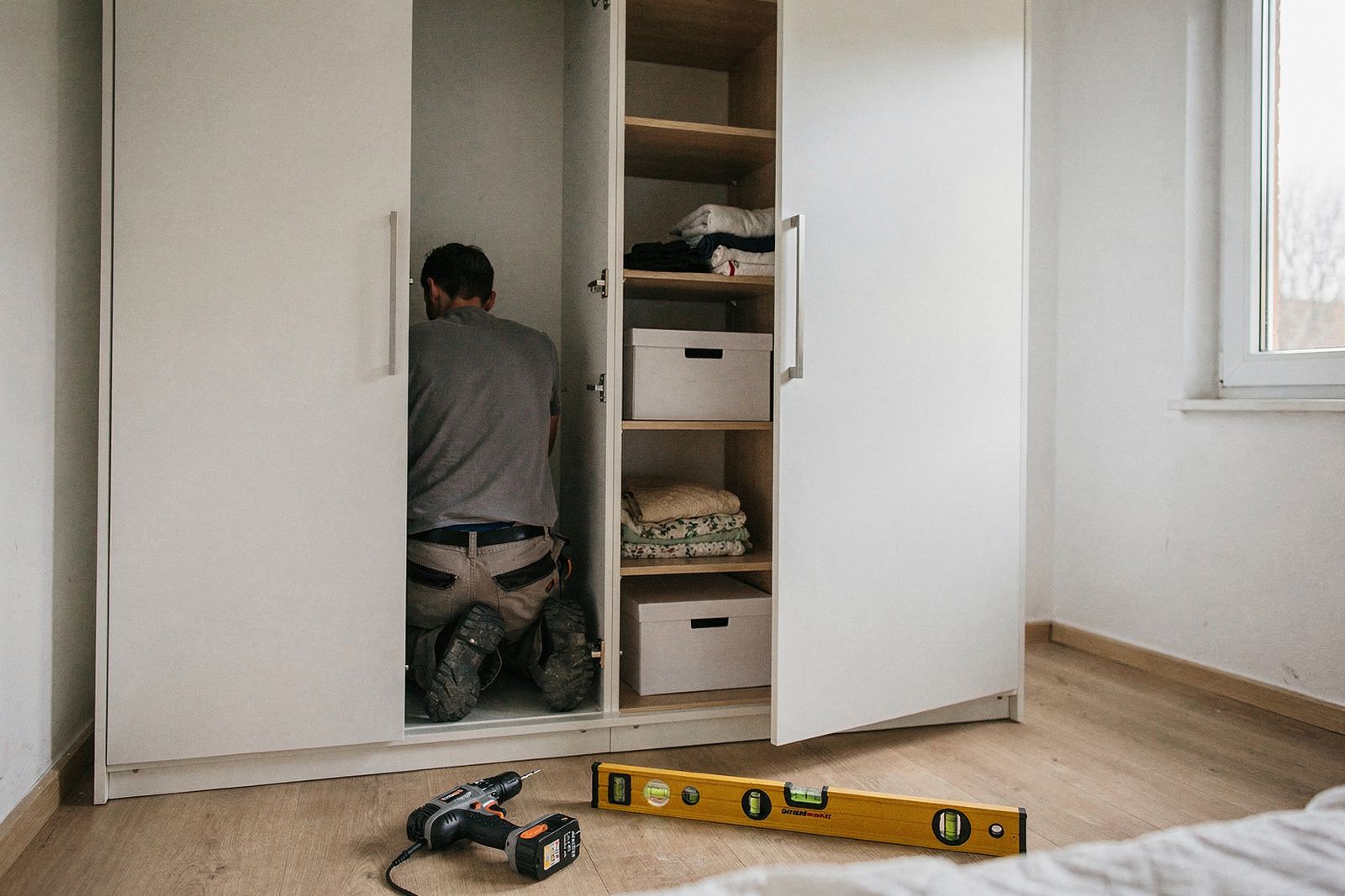 Weißer Einbauschrank mit Schiebetüren in einer Wandnische, frisch montiert